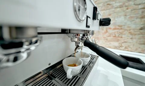 Preparing two cups of coffee on an espresso machine in a coffee shop. Stock Photos