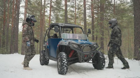 Preparing UTV for snowy adventure. Two individuals gear up for offroad journey Stock Footage 332167800