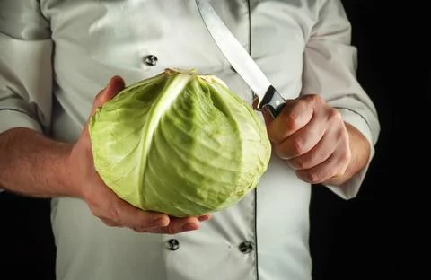 Preparing a vegetable dish for dinner. Cabbage and a knife in the hands of .. Stock Photos