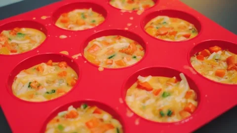 Preparing vegetable egg muffins in silicone cupcake mold indoors Stock Footage 342886040