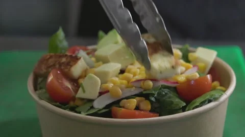 Preparing vegetable salad with grilled cheese in eco-friendly paper bowl Stock Footage 246238059