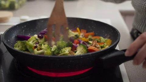 Preparing vegetables on a frying pan for healthy vegan dinner Stock Footage 109273418