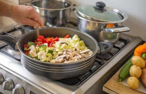 Preparing vegeterian dish in a deep pan Stock Photos