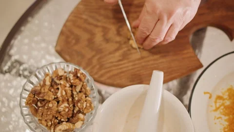 Preparing walnuts with careful precision. Crafting pumpkin pie topping with warm Stock Footage 346410121