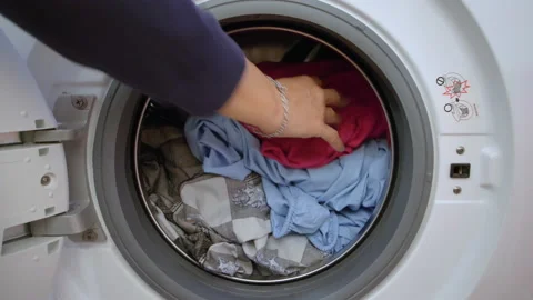 Preparing the wash cycle. Washing machine, hands and clothes 動画素材 145721507