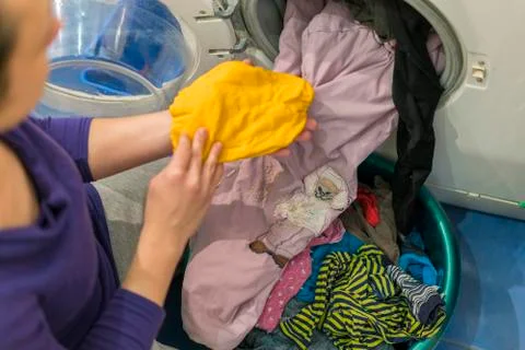 Preparing the wash cycle. Washing machine, hands and clothes. Foto stock