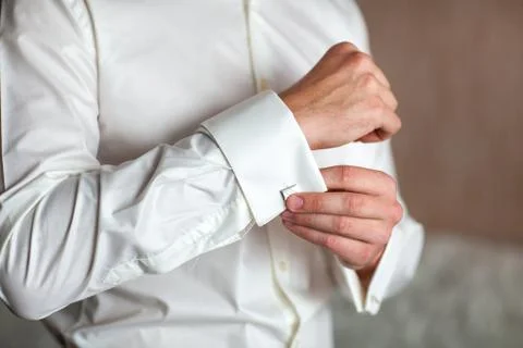 Preparing for wedding. Groom buttoning cufflinks on white shirt before wedd.. Stock Photos