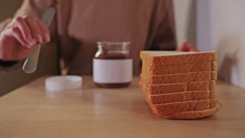 Preparing White Bread With Sweet Chocolate Spread In A Warm Kitchen Setting Stock Footage 340258303