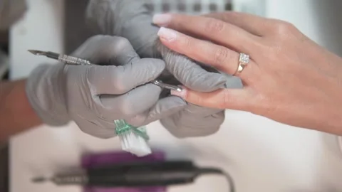 Preparing a womans fingernails for cuticle removal. Stock Footage 309625789
