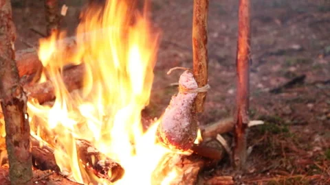 A prepper cooks food on an open fire. Stock Footage 208829907