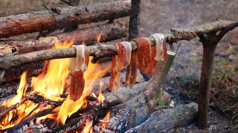 A prepper cooks food on an open fire. Stock Footage 244703226