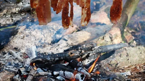 A prepper cooks food on an open fire. Stock Footage 244703273