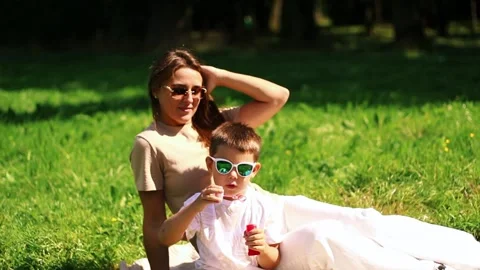 Preschool boy having fun blowing soap bubbles in park. Game of blowing bubble Stock Footage 319471054