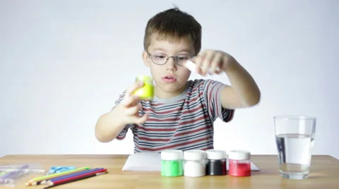 Preschool boy opens jars with paint Stock Footage 47443650
