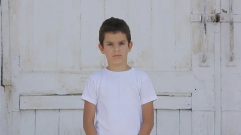 Preschool child boy looking at camera and start to smile, outside. Stock Footage 113468045