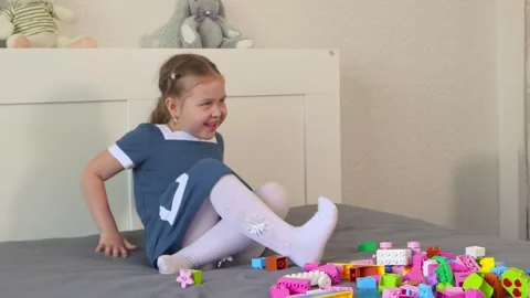 Preschool child builds structures with toy cubes, practicing motor coordination Video stock 335943180