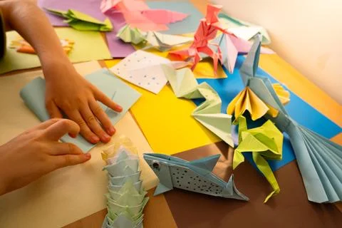 Preschool child making origami animals with colorfull papers Stock Photos