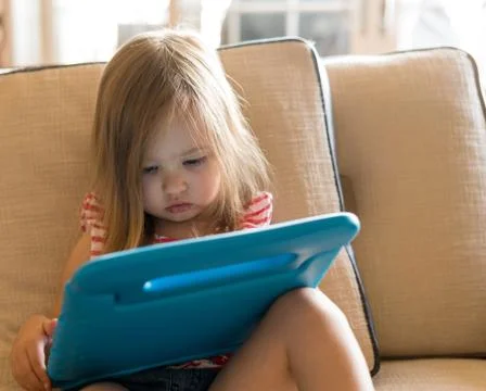 Preschool girl using a tablet computer at home Stock Photos