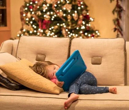 Preschool girl using a tablet computer at home at Christmas Stock Photos