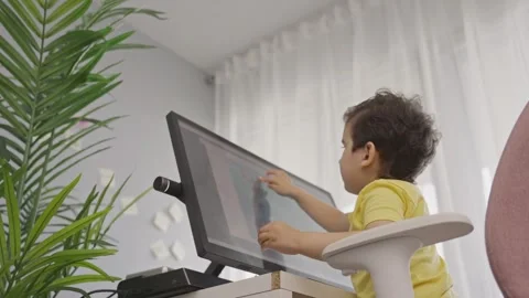 Preschool kid touching the screen of computer during online education Stock Footage 246086086