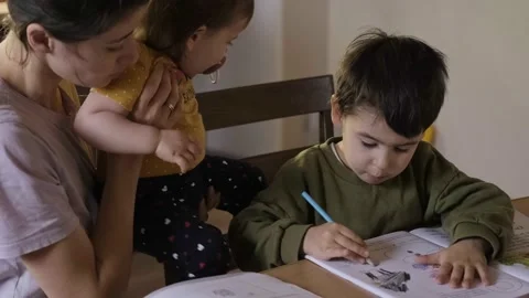 Preschooler boy kid sit at table drawing painting picture in album, caucasian Stock Footage 176595069