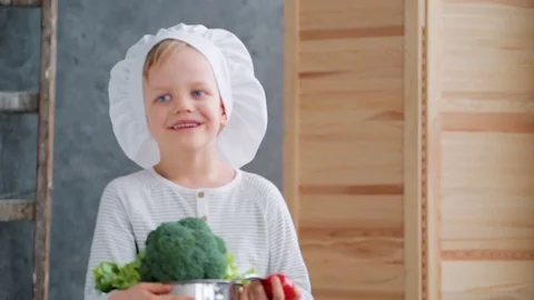 Preschooler with chief hat sorting and exploring the healthy food 库存影片 74561430