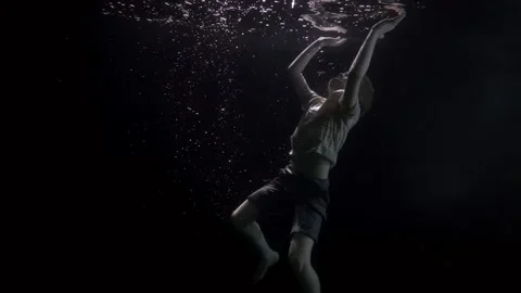 Preschooler child is sinking inside river or sea, underwater slow motion shot Stock Footage 153610352