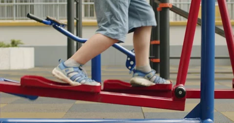 Preschooler does exercise on running trainer on playground Stockbeeldmateriaal 205070066