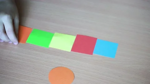 Preschooler plays with paper geometric details, game for creativity. Leisure of Stock Footage 221677458