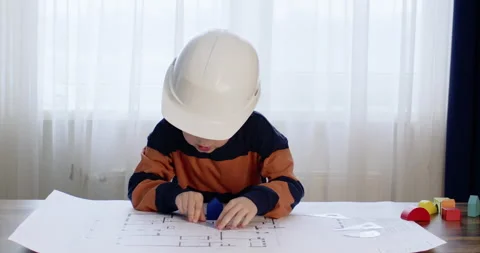 Preschooler pretends to be engineer and points to drawing 動画素材 244374413