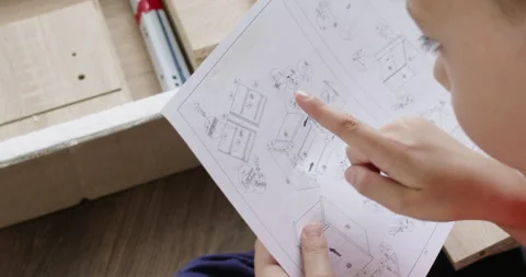 Preschooler studies instructions carefully assembling nightstand Stockbeeldmateriaal 286045802