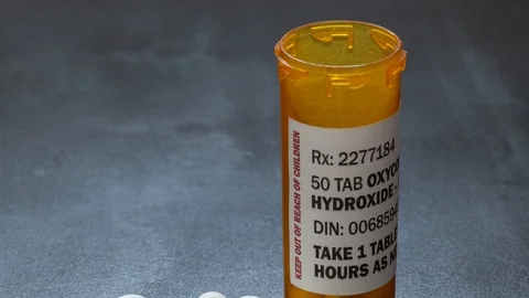 Prescription bottle with backlit Oxycodone tablets, a generic opioid. Stock-Footage 118837781