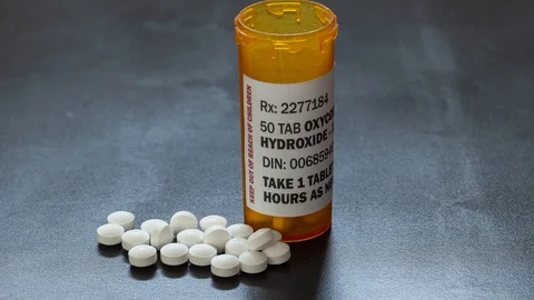 Prescription bottle with backlit Oxycodone tablets, a generic opioid. 스톡 동영상 118837907