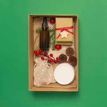 Present box with cosmetics on green background Stock Photos
