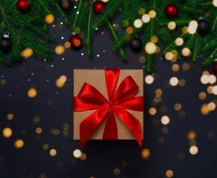 Present box with decorations on black background Stock Photos