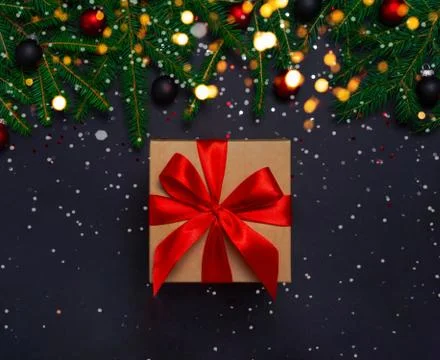 Present box with decorations on black background Stock Photos