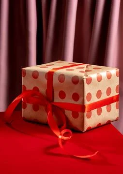 Present box with red bow on red background Foto stock
