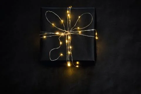 Present Box wrapped with string lights Stock Photos