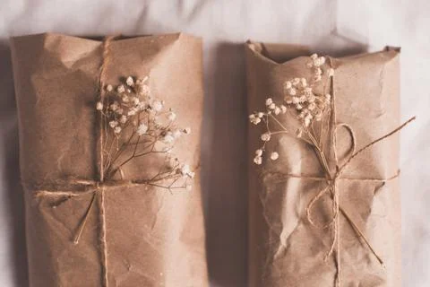 Present boxes with craft paper and dry flowers closeup. Birthday celebration. Foto stock