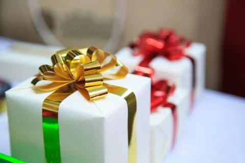 Present boxes package with gold and red ribbons as holiday gift boxes for fes Stock Photos