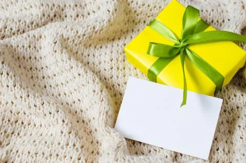 Present With Empty Postcard on Beige Knitted blanket background. Stock Photos