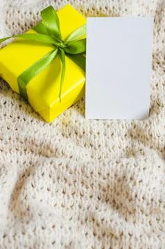 Present With Empty Postcard on Beige Knitted blanket background. Stock Photos