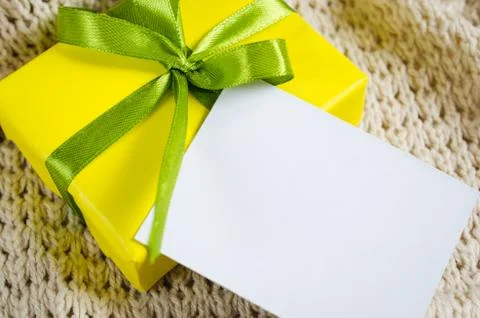 Present With Empty Postcard on Beige Knitted blanket background. Stock Photos