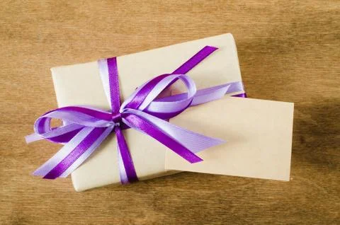 Present with Empty Tag on Wooden Background. Stock Photos