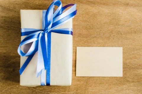 Present with Empty Tag on Wooden Background. Stock Photos