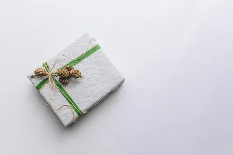 Present gift box wrapped with white paper and green ribbon Stock Photos