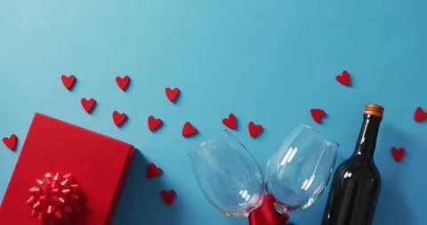 Present, hearts and wine glasses on blue background at valentine's day Stock-Footage 344533895