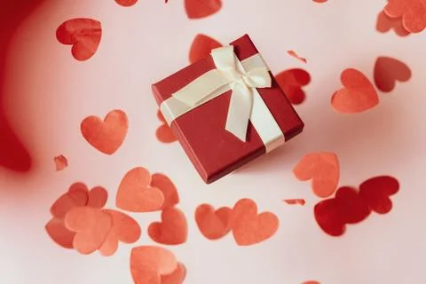 Present or gift box, paper heart and confetti on Valentines day greeting card. Stock Photos