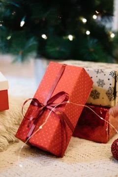 Present packed with red paper on dots under tree Foto stock