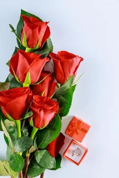 Present ring in red box and bouquet of beautiful red roses. Mothers Day. Stock Photos